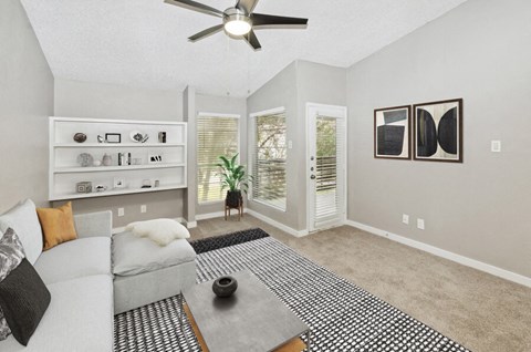 a living room with a couch and a ceiling fan